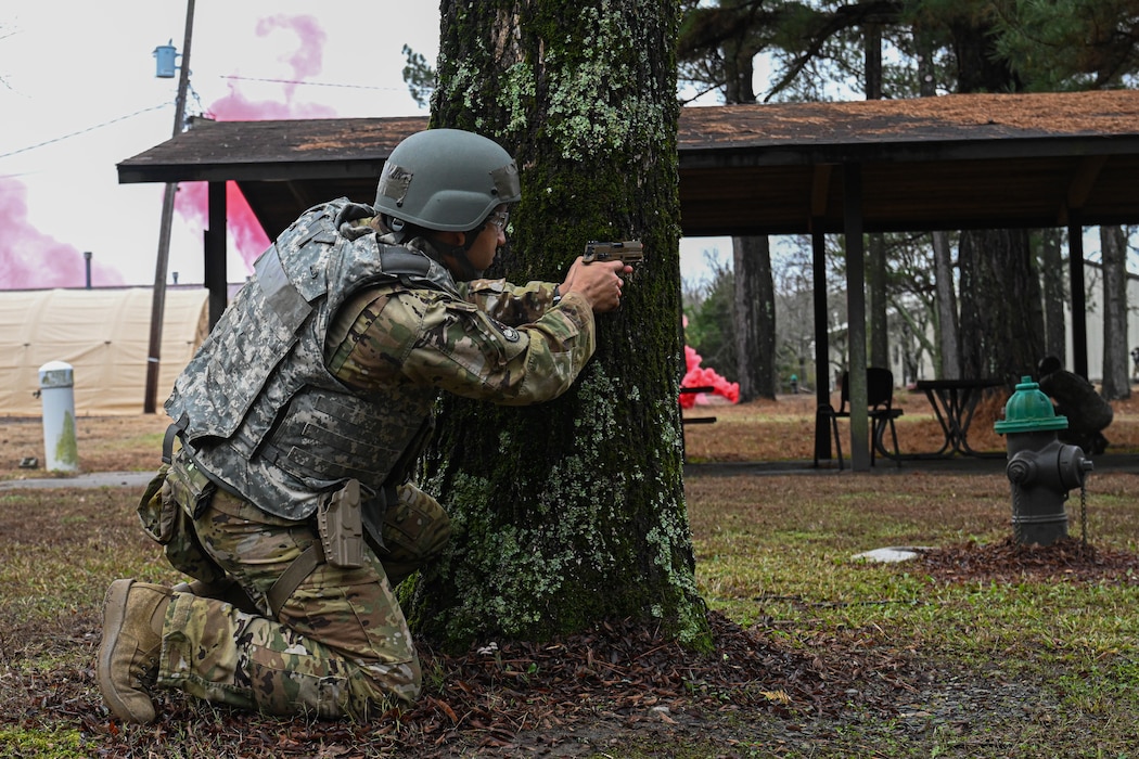 An Airman takes cover behind a tree.