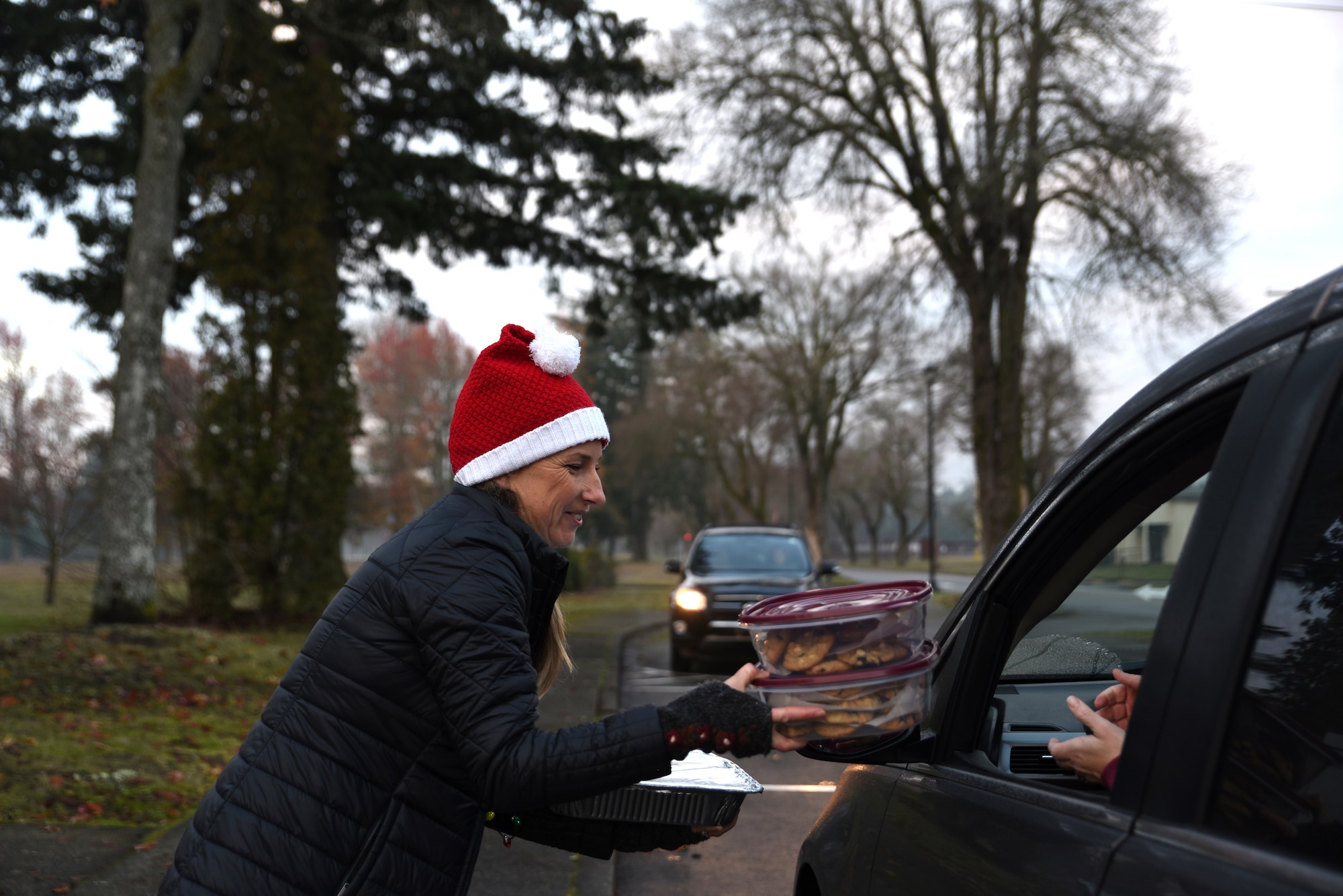 A Team McChord volunteer receives a batch of cookies from a donor for Operation Cookie Drop at Joint Base Lewis-McChord, Washington, Dec. 14, 2022. Operation Cookie Drop is an Air Force tradition that supports single Airmen who are far from home during the holidays. (U.S. Air Force photo by Airman Kylee Tyus)