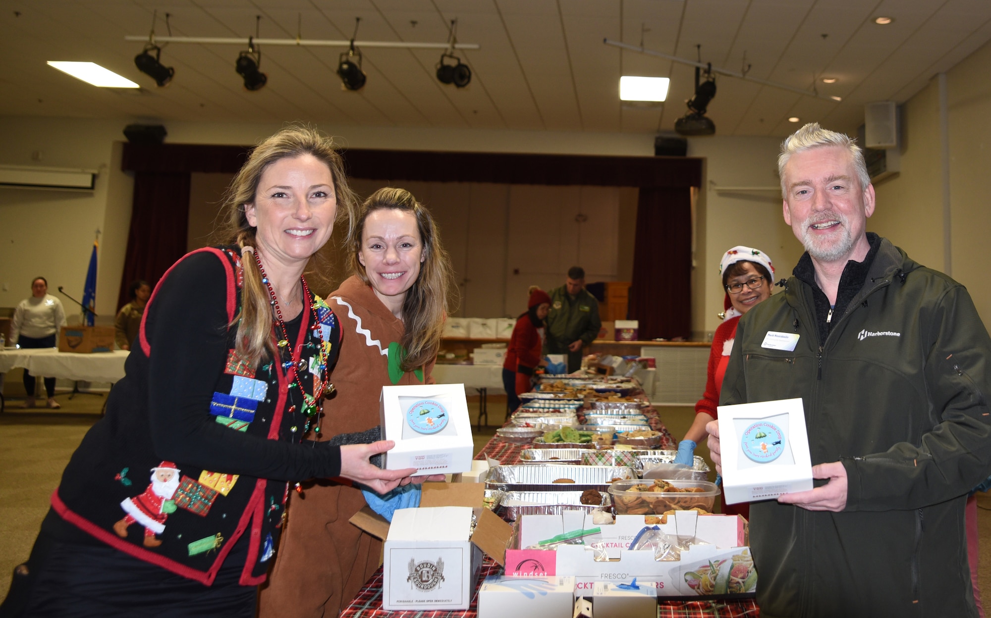 Mark Minickiello, right, vice president of community development at Harborstone Credit Union, poses for a picture with Team McChord volunteers during Operation Cookie Drop at Joint Base Lewis-McChord, Washington, Dec. 14, 2022. Minickiello donated the boxes and stickers that were used to distribute the cookies baked for Operation Cookie Drop. (U.S. Air Force photo by Airmen Kylee Tyus)