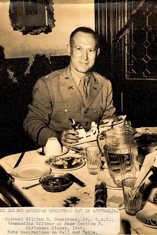 An officer eats at a table.