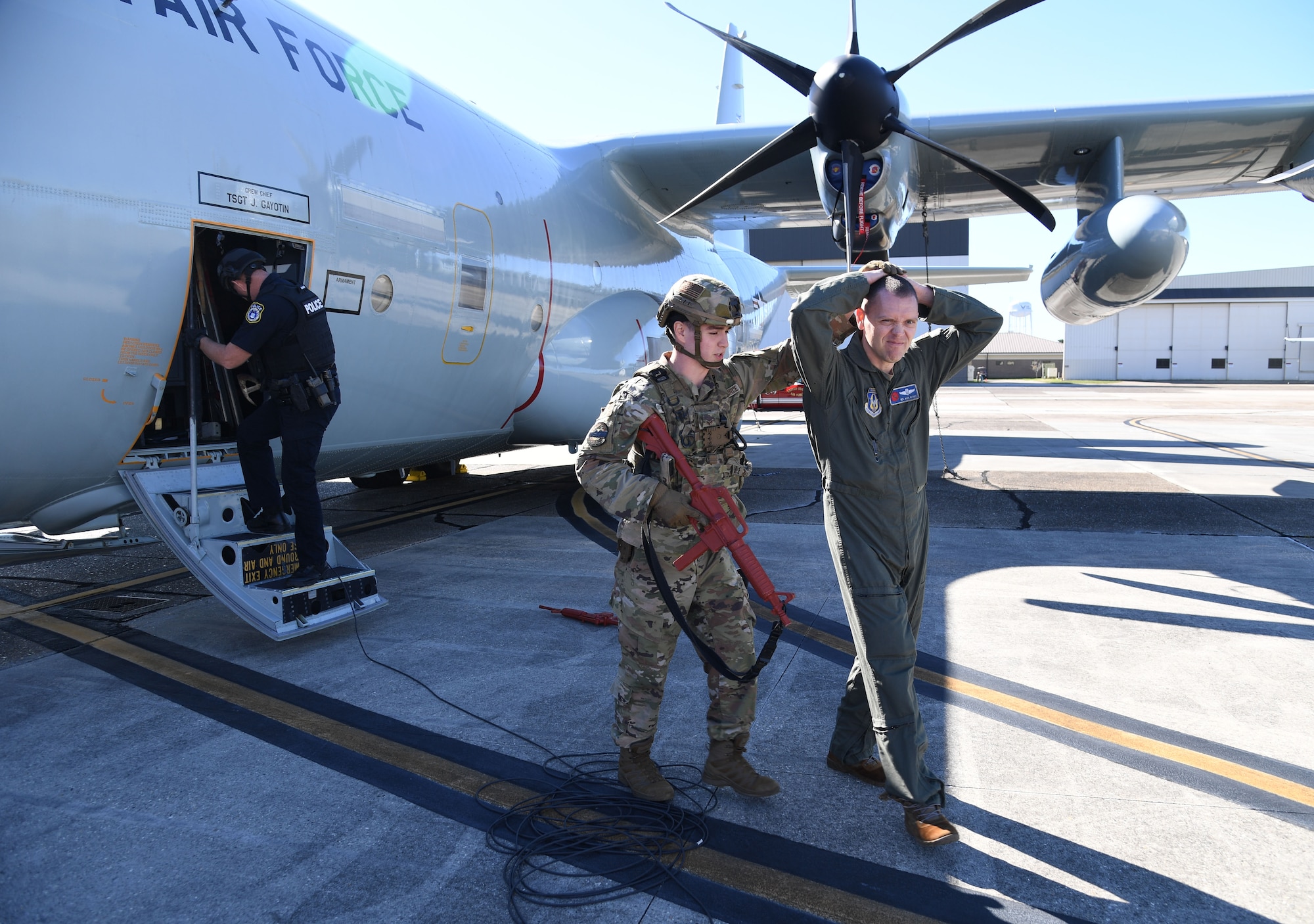 U.S. Air Force Senior Airman James Boyter, 81st Security Forces Squadron patrolman, escorts Lt. Col. Mark Withee, 403rd Wing navigator, as he portrays a "hijacker", from the aircraft during a hijacking exercise at Keesler Air Force Base, Mississippi, Dec. 15, 2022.