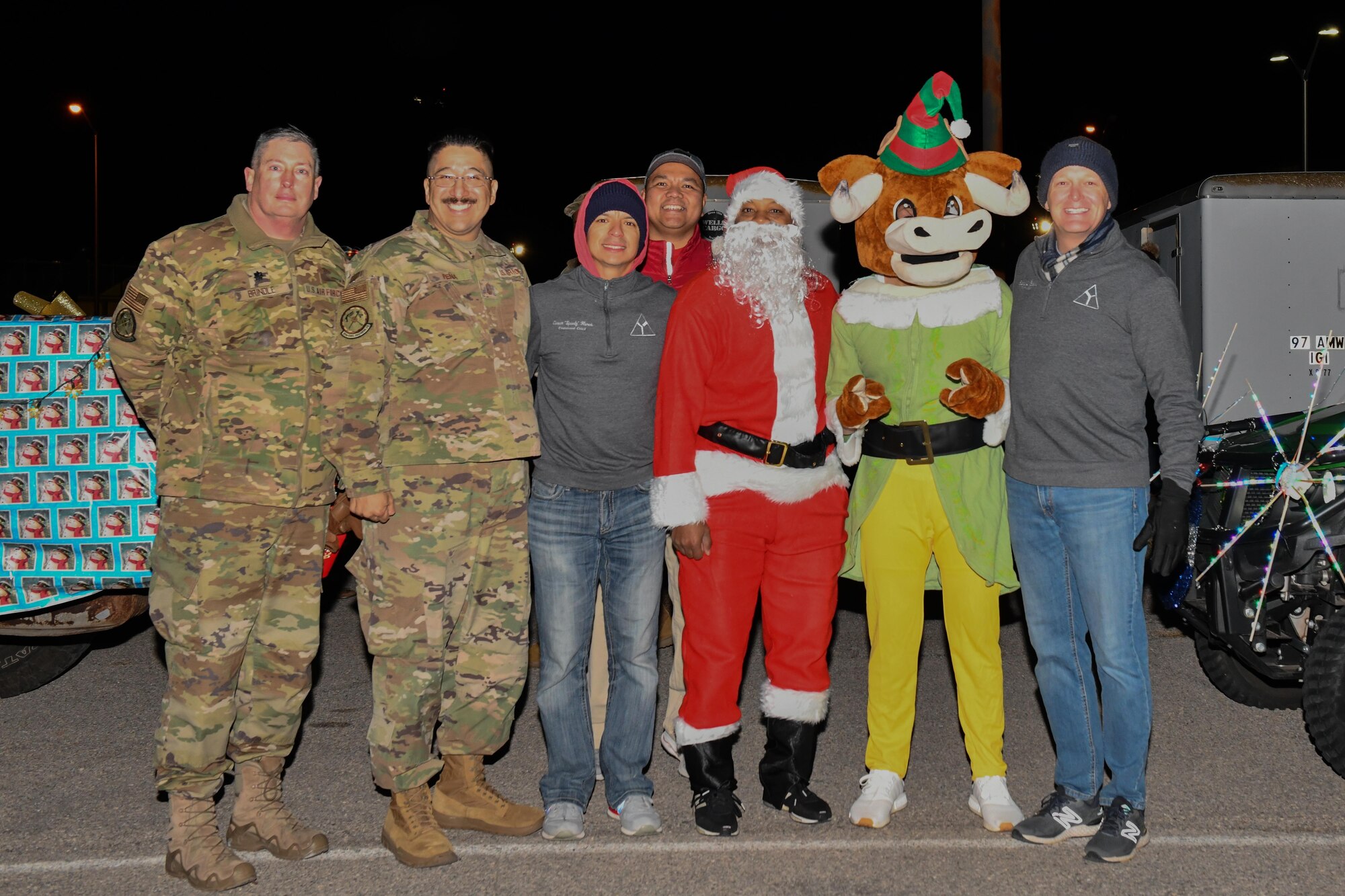 Airmen and leadership from the 97th Air Mobility Wing pose for a photo after a holiday parade at Altus Air Force Base, Oklahoma, December 13, 2022. The purpose of the parade is to provide holiday cheer and promote friendly competition. (U.S. Air Force photo by Airman 1st Class Miyah Gray)