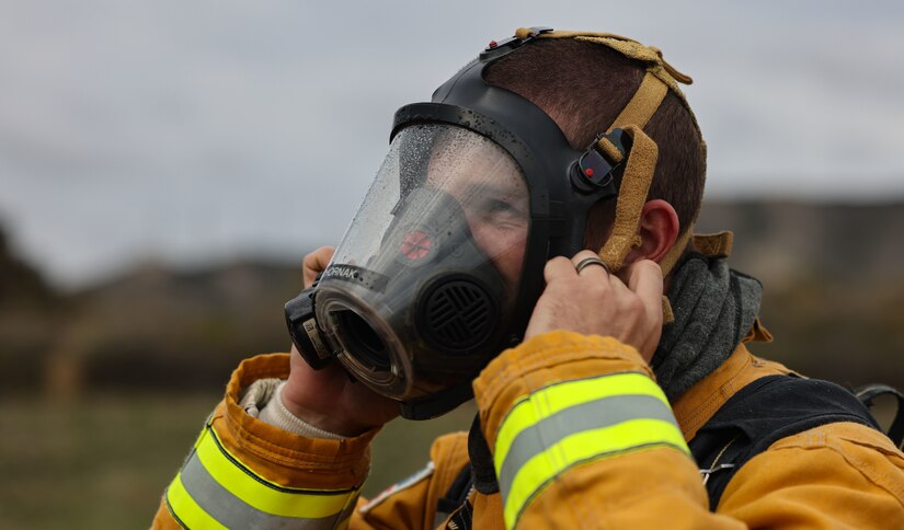 A person wears protective face gear and holds on to the sides of it.