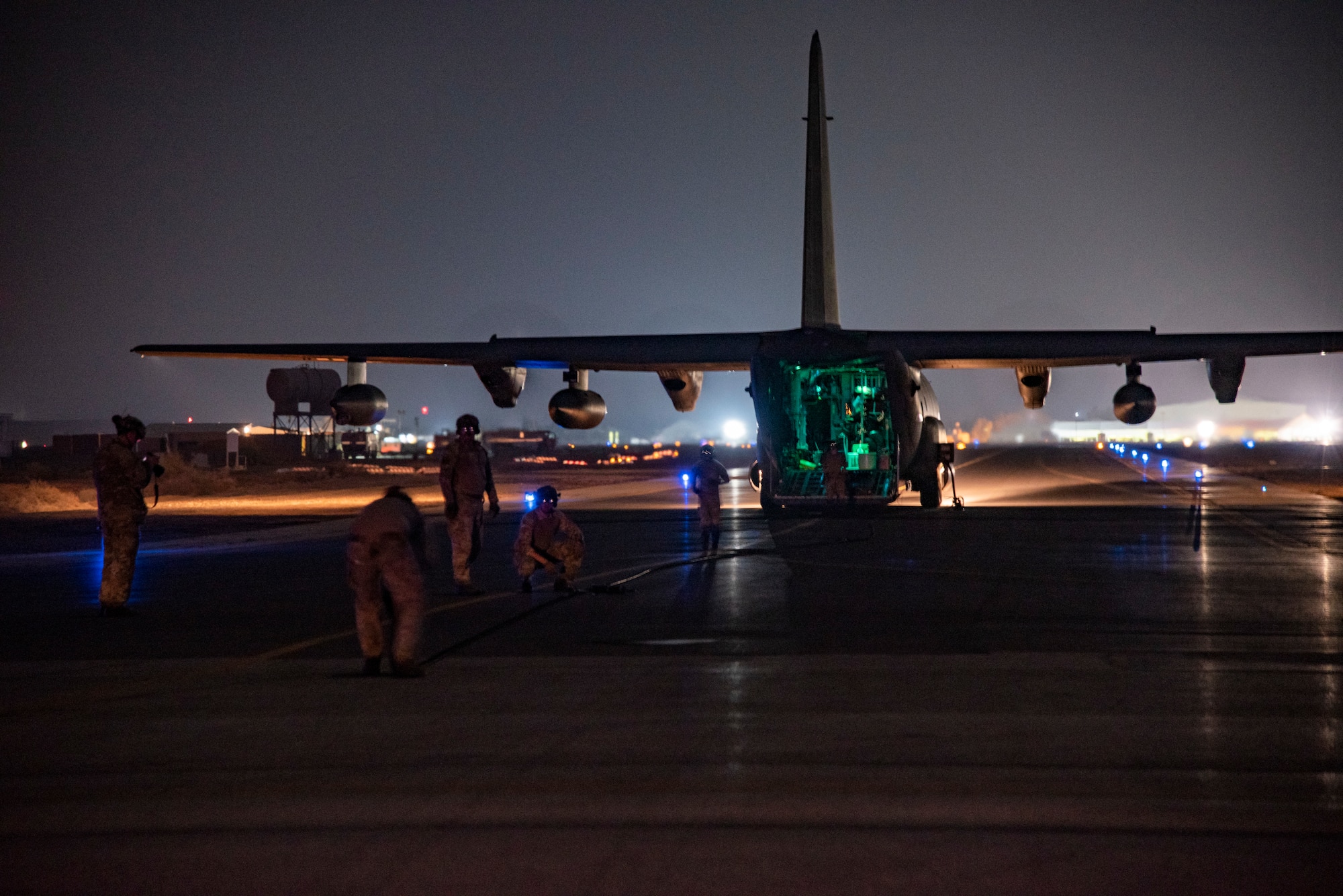 26th Expeditionary Rescue Squadron Forward Arming and Refueling Point specialists recover fuel lines on a flight line at an undisclosed location, Southwest Asia, Dec. 11, 2022, preparing to board an HC-130J Combat King II.  (U.S. Air Force photo by: Tech. Sgt. Jim Bentley)