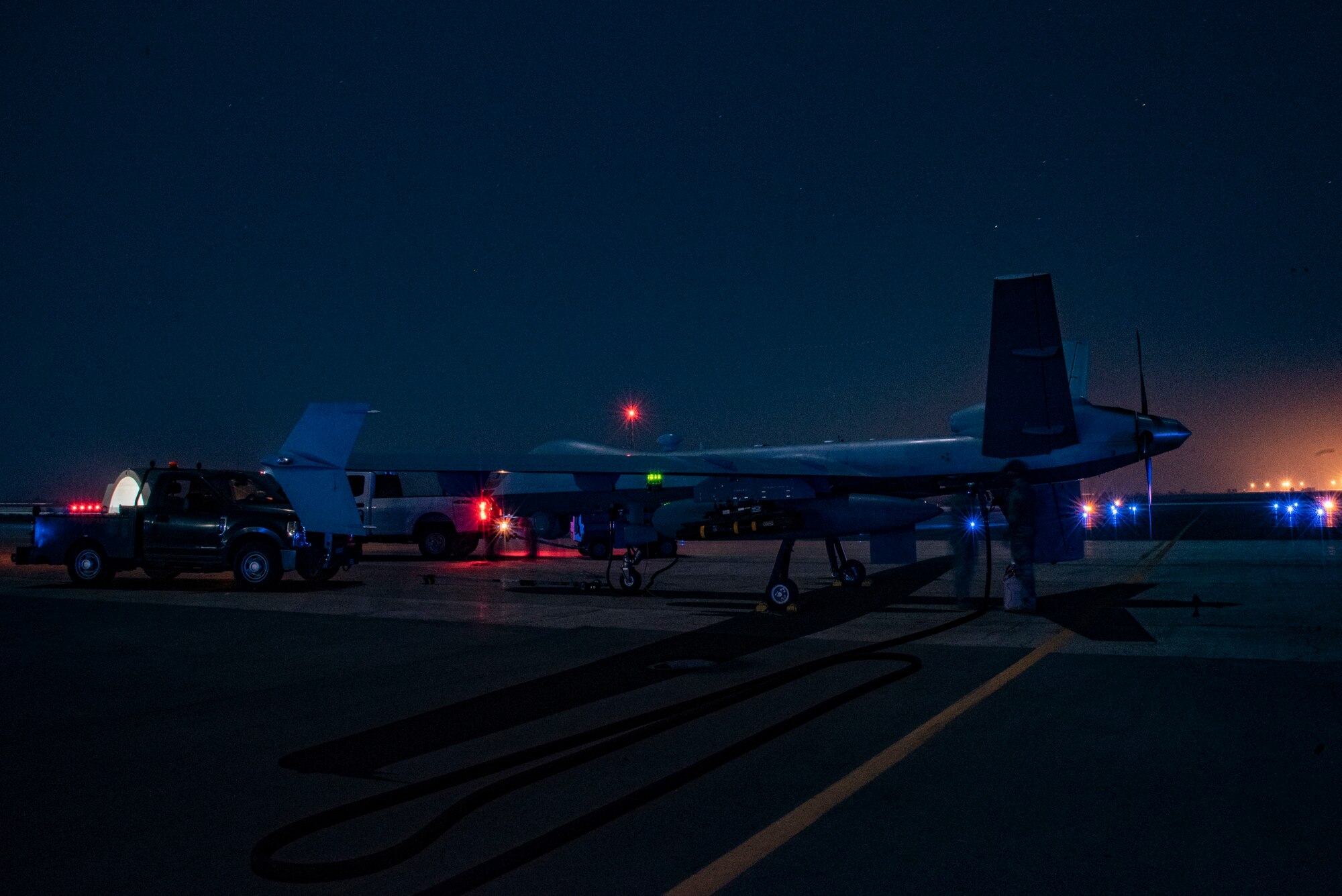26th Expeditionary Rescue Squadron Forward Arming and Refueling Point specialists refuel a 361st Expeditionary Attack Squadron MQ-9 Reaper on a flight line at an undisclosed location, Southwest Asia, Dec. 10, 2022.  (U.S. Air Force photo by: Tech. Sgt. Jim Bentley)