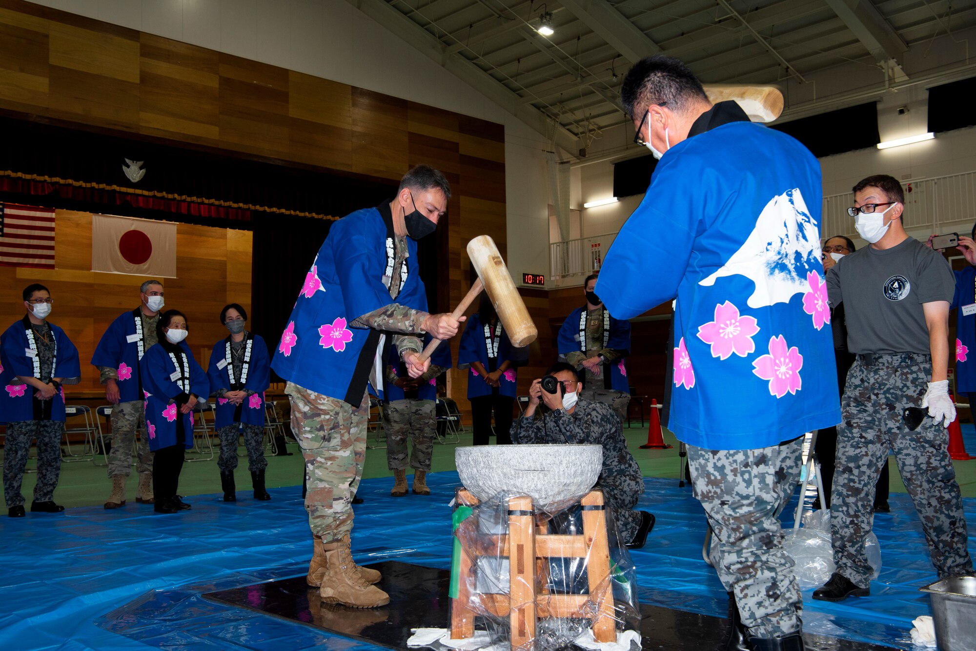 U.S. Air Force Col. Andrew Roddan, 374th Airlift Wing commander, and Japan Air Self-Defense Forces Col. Takashi Izuhara, Operation Support Wing commander, take turns pounding mochi at the Operation Support Wing annual mochi pounding ceremony on Dec. 14, 2022, Yokota Air Base, Japan. The process of making mochi is a culturally significant symbol of teamwork and partnership, as it requires collaborative time and effort. (U.S. Air Force photo by Tech Sgt. Taylor A. Workman)