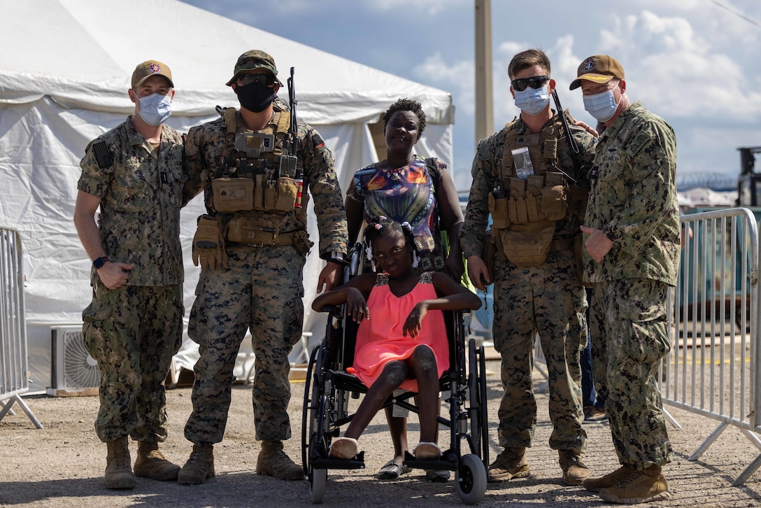 U.S. Marines and Sailors pause to take a photo with local civilians while supporting Continuing Promise 2022 in Jeremie, Haiti, Dec. 12, 2022. The Continuing Promise mission includes providing direct medical care and expeditionary veterinary care, conducting training and subject matter expert exchanges on various medical and humanitarian assistance/disaster relief topics, and leading seminars on Women, Peace, and Security (WPS). (U.S. Marine Corps photo by Lance Cpl. Ryan Ramsammy)