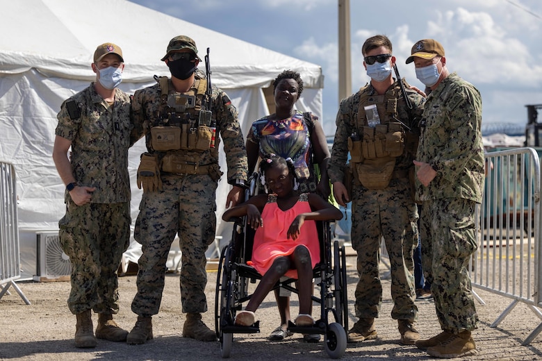 U.S. Marines and Sailors pause to take a photo with local civilians while supporting Continuing Promise 2022 in Jeremie, Haiti, Dec. 12, 2022. The Continuing Promise mission includes providing direct medical care and expeditionary veterinary care, conducting training and subject matter expert exchanges on various medical and humanitarian assistance/disaster relief topics, and leading seminars on Women, Peace, and Security (WPS). (U.S. Marine Corps photo by Lance Cpl. Ryan Ramsammy)