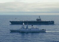 The Nimitz-class aircraft carrier USS George H.W. Bush (CVN 77) sails alongside the Italian Navy Andrea Doria-class air defense destroyer ITS Andrea Doria (D 553) while an MH-60R Knighthawk, assigned to Carrier Air Wing (CVW) 7, takes off during combined operations in the Adriatic Sea, Dec. 15, 2022.