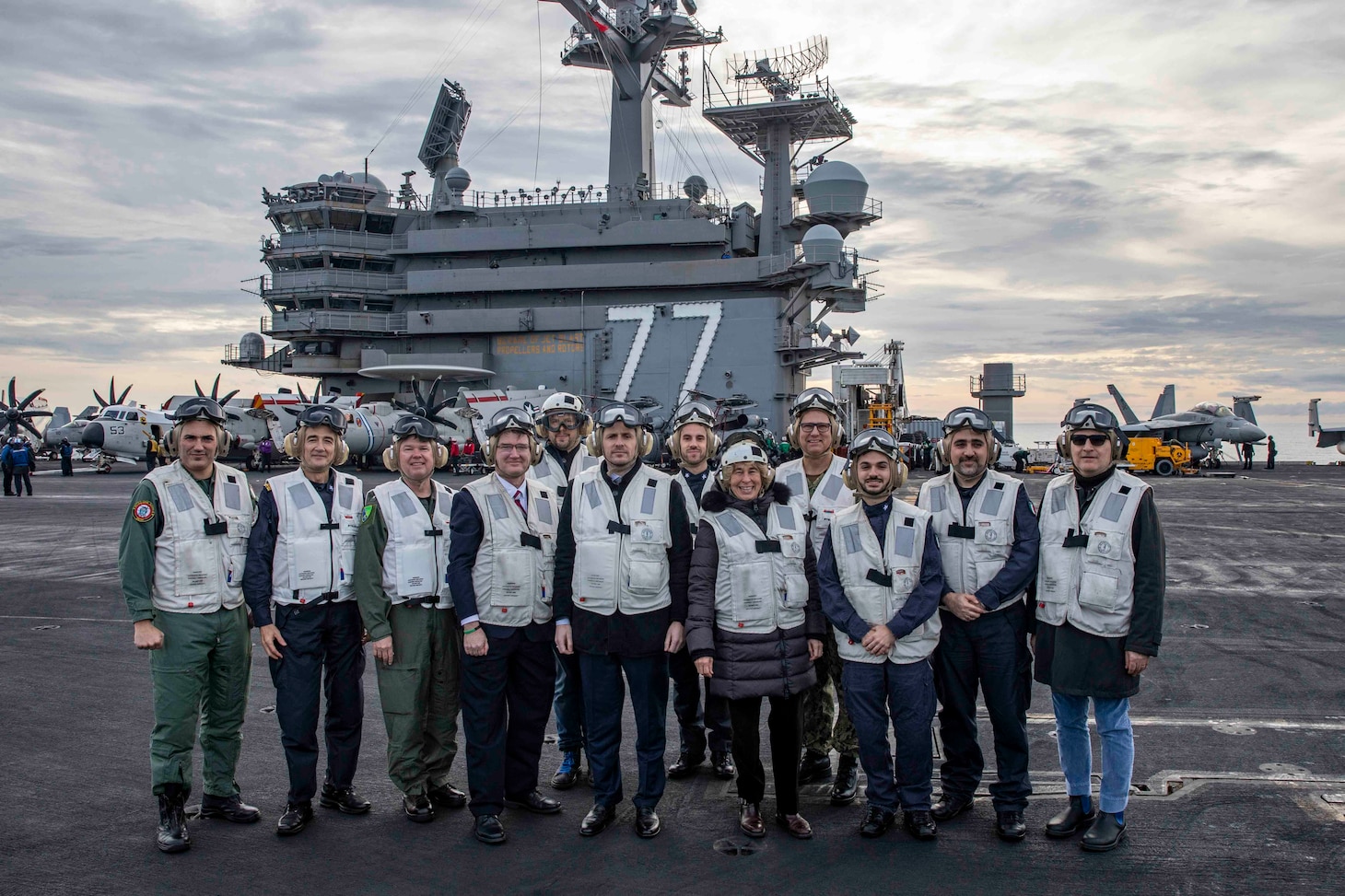 Italian senior civilian and military leadership pose for a group photo on the flight deck of the Nimitz-class aircraft carrier USS George H.W. Bush (CVN 77) during a distinguished visitor embark on the ship, Dec. 15, 2022.