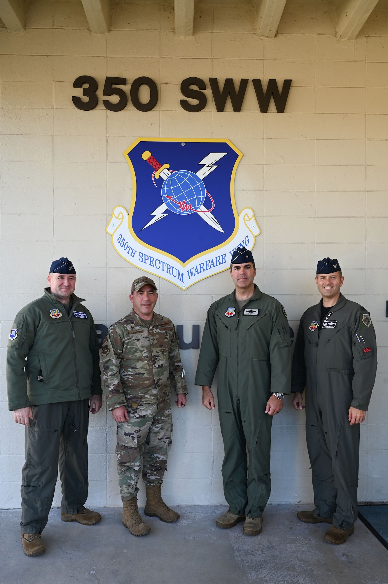 U.S. Air Force Col. Robert Cocke, 350th Spectrum Warfare Group commander, left, Col. Josh Koslov, 350th Spectrum Warfare Wing  commander, center left, Brig. Gen. Richard Goodman, 57th Wing commander, center right, and Col. John Paul Mintz, 850th Spectrum Warfare Group commander, right, pose for a photo at Eglin Air Force Base, Fla., Dec. 16, 2022. The 350th SWW’s mission is to develop and employ evolutionary, cutting-edge capabilities for warfighters that will make decisive impacts in battle, achieving commanders’ objectives and allowing warfighters to beat pacing competitors across the spectrum. (U.S. Air Force photo by Staff Sgt. Ericka A. Woolever)