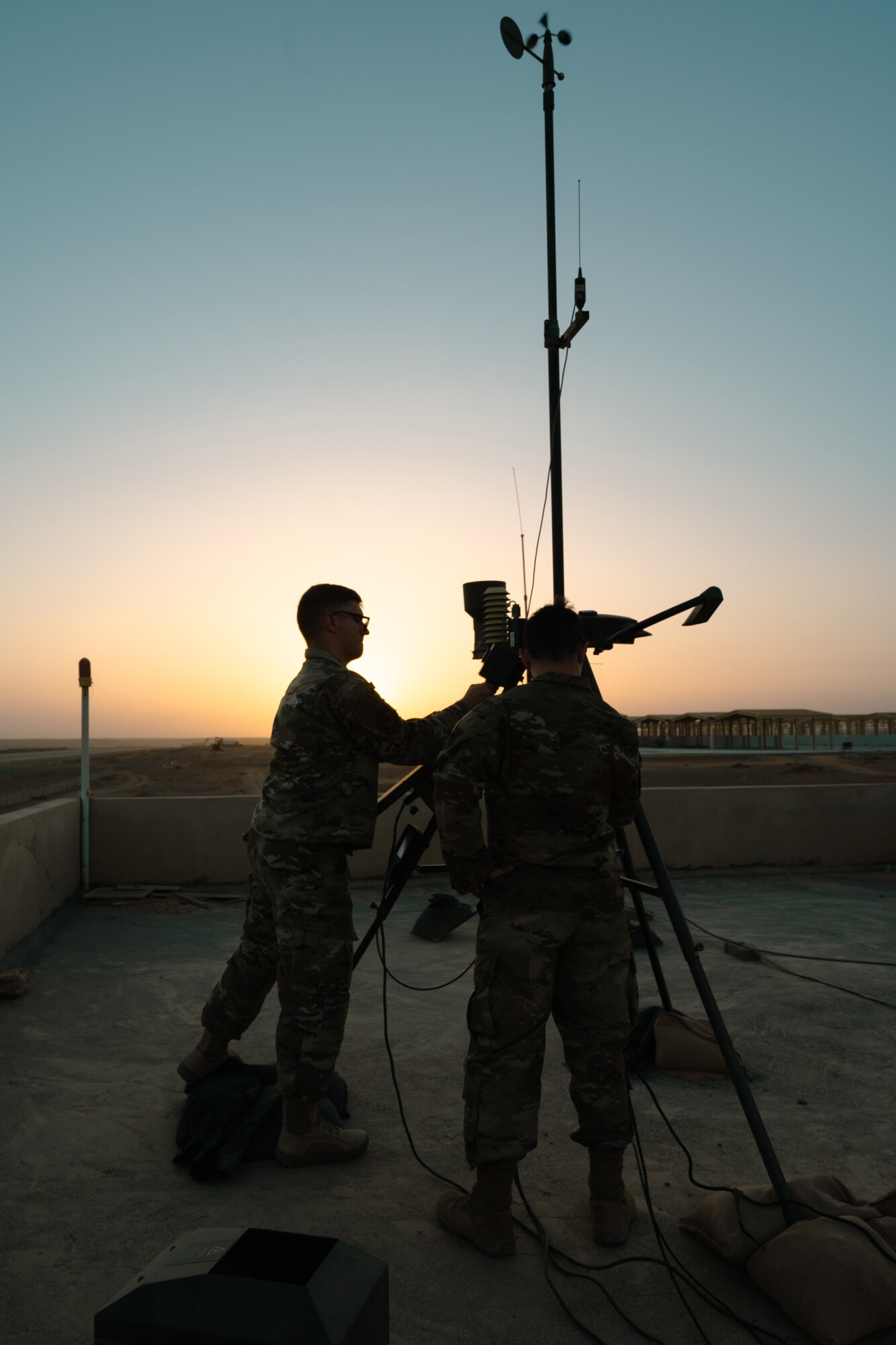 Tech. Sgt. Christopher Hahaj, Weather Flight Chief, 332d Expeditionary Operations Support Squadron, left, and Senior Airman Carmen Ricco, Forecaster, 332d Expeditionary Operations Support Squadron, work on a TMQ-53 tactical weather observing system, at an undisclosed location, Sept. 29, 2022. The TMQ-53 monitors and records current weather conditions by automating weather observations for forecasters. (U.S. Air Force photo by Tech. Sgt. Richard Mekkri)