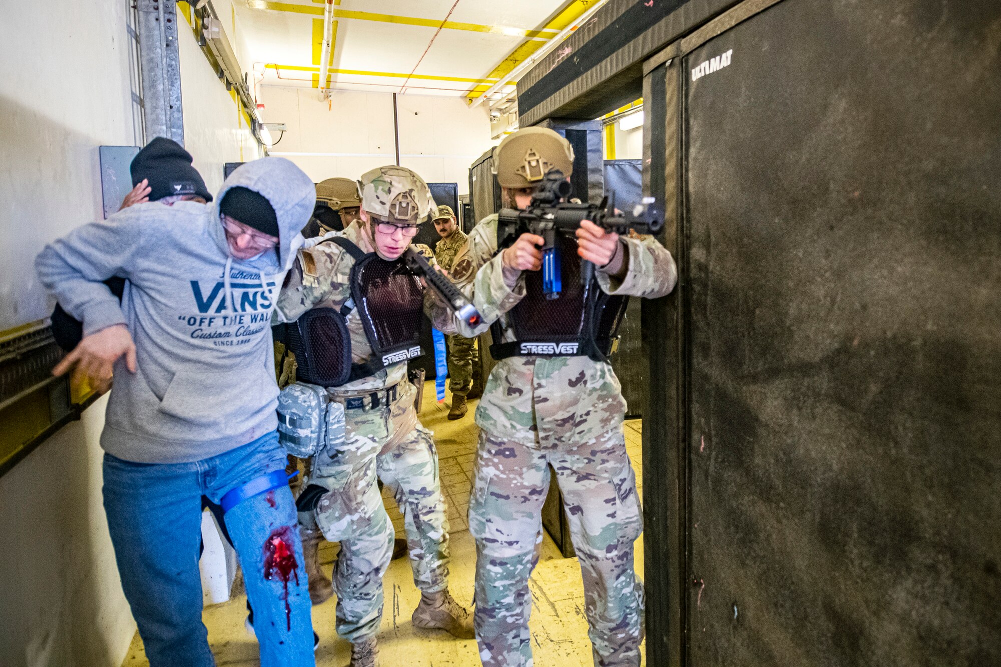 Airmen from the 423d Security Forces Squadron escort a simulated victim, left, to a safe location during an active shooter exercise at RAF Molesworth, England, Dec. 16, 2022. The 423d SFS and Medical Squadrons conducted the exercise to evaluate their overall readiness and response capabilities to an emergency situation. (U.S. Air Force photo by Staff Sgt. Eugene Oliver)