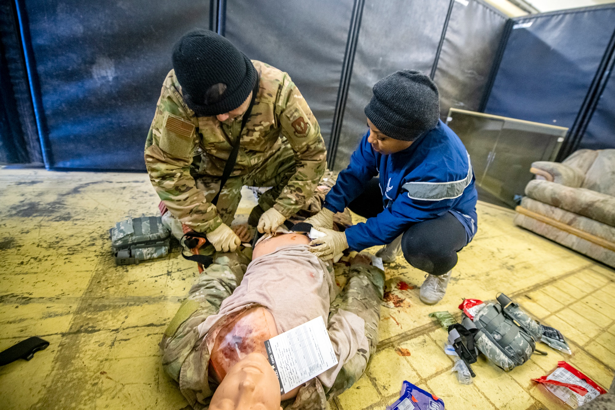 Airmen from the 423d Medical Squadron apply tactical combat casualty care to a simulated victim during an active shooter exercise at RAF Molesworth, England, Dec. 16, 2022. The 423d MDS and Security Forces Squadrons conducted the exercise to evaluate their overall readiness and response capabilities to an emergency situation. (U.S. Air Force photo by Staff Sgt. Eugene Oliver)