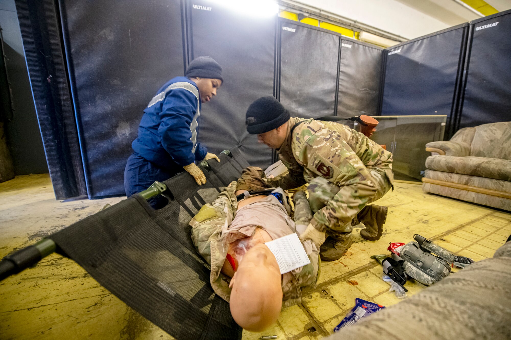 Airmen from the 423d Medical Squadron place a simulated victim on a stretcher during an active shooter exercise at RAF Molesworth, England, Dec. 16, 2022. The 423d MDS and Security Forces Squadrons conducted the exercise to evaluate their overall readiness and response capabilities to an emergency situation. (U.S. Air Force photo by Staff Sgt. Eugene Oliver)