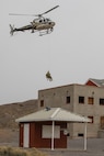 Utah National Guard members are airlifted onto a building during a simulated earthquake disaster exercise consisting of the Utah National Guard FEMA Region VIII Homeland Response Force and state emergency personnel on Camp Williams, Utah, Nov. 5, 2022. The event featured multi-agency interoperability training for the Utah National Guard and civilian partner agencies to provide initial and follow-on care to stranded and injured citizens in the event of a natural or human-caused emergency. (U.S. Army National Guard photo by Sgt. Alejandro Lucero)