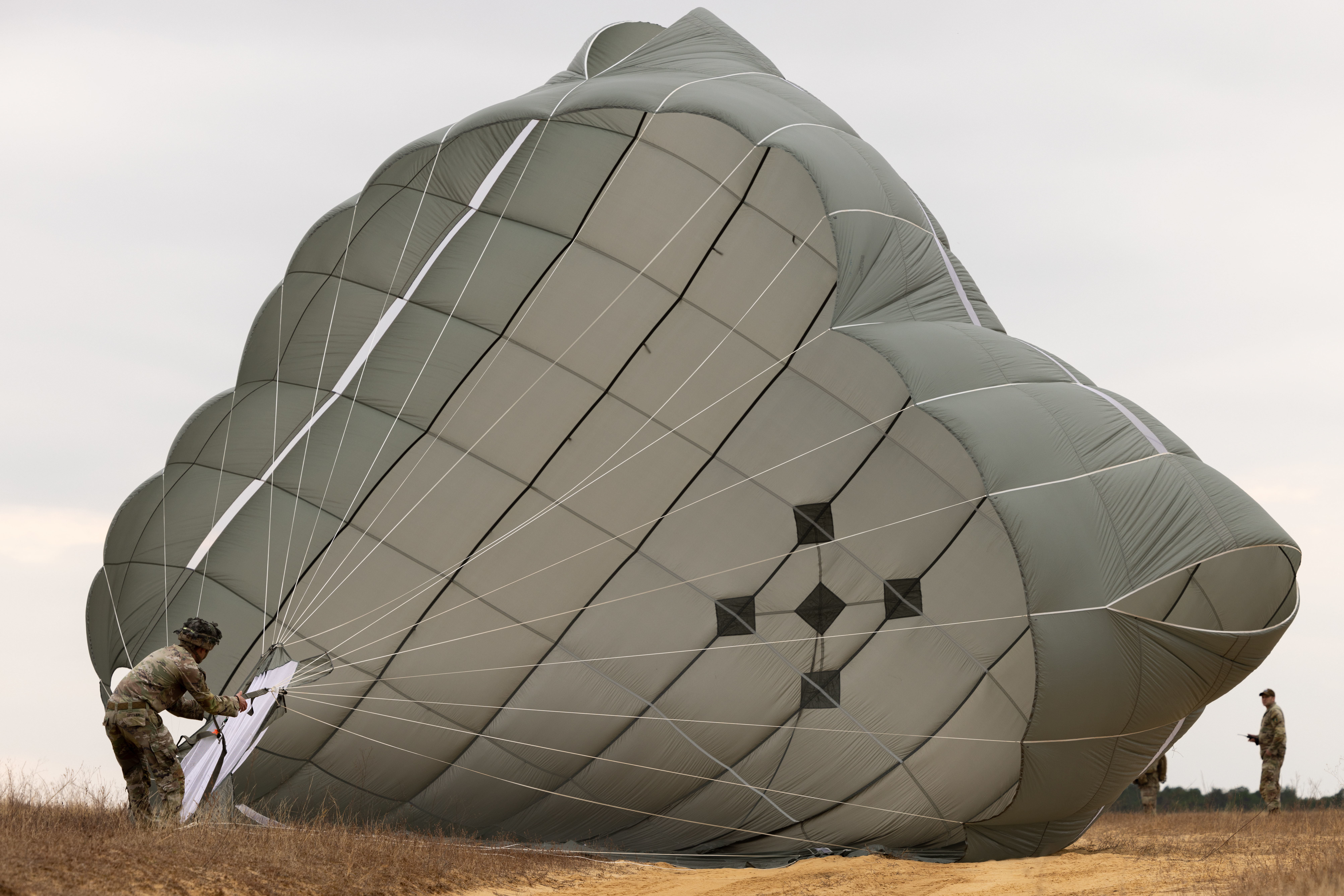 A solider packs a large parachute.