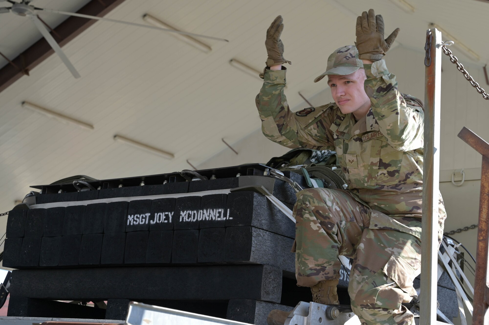 a person guides a cargo loader in place