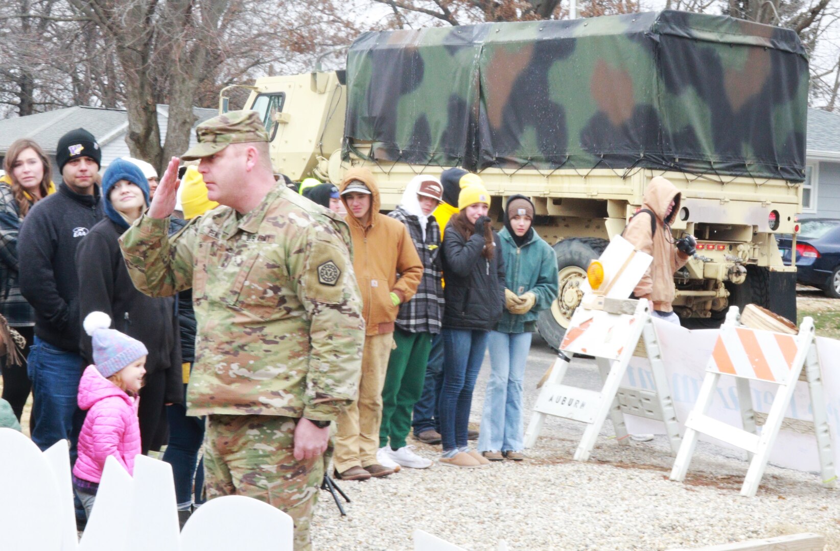 Illinois National Guard Master Sgt. Ken Pence, the operations noncommissioned officer for the 232nd Combat Sustainment Support Battalion, salutes June Peden-Stade, 3, for her courage during a parade in her honor in Auburn, Illinois, Dec. 17, 2022.