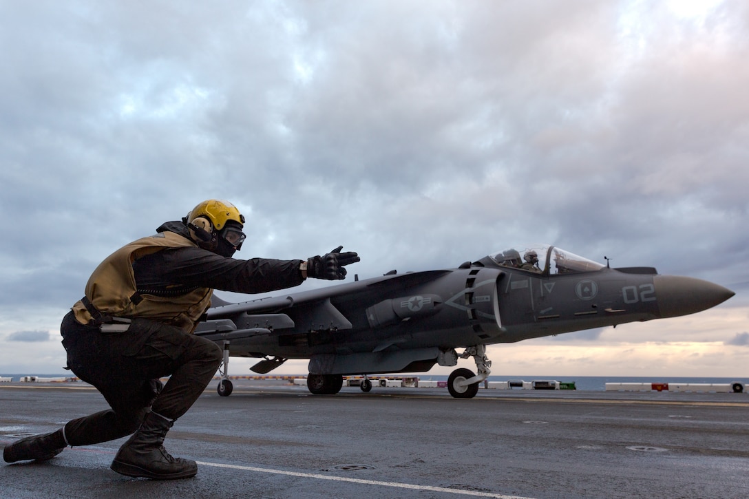 U.S. Marine Corps Capt. Robert Weede, an AV-8B Harrier II jet pilot with Marine Attack Squadron (VMA) 231, receives the signal for takeoff from U.S. Navy Aviation Boatswain’s Mate (Handling) 3rd Class Donahven Beaver on the flight deck aboard the amphibious assault ship USS Kearsarge (LHD 3), Dec. 6, 2022. VMA-231 trained with U.S. Sailors to strengthen interoperability and conduct carrier qualifications prior to their upcoming deployment with the 26th Marine Expeditionary Unit. VMA-231 is a subordinate unit of 2nd Marine Aircraft Wing, the aviation combat element of II Marine Expeditionary Force. (U.S. Marine Corps photo by Cpl. Christian Cortez)