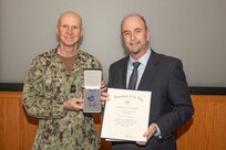 Naval Surface Warfare Center, Philadelphia Division Commanding Officer Capt. Dana Simon, presents the Meritorious Civilian Service Medal to Edward Harvey for his achievements as Test Manager, Lead Engineer, and Chief Test Engineer at NSWCPD during the command’s quarterly awards ceremony on Nov. 2, 2022. (U.S. Navy Photo by Sgt. Jermaine Sullivan/Released)