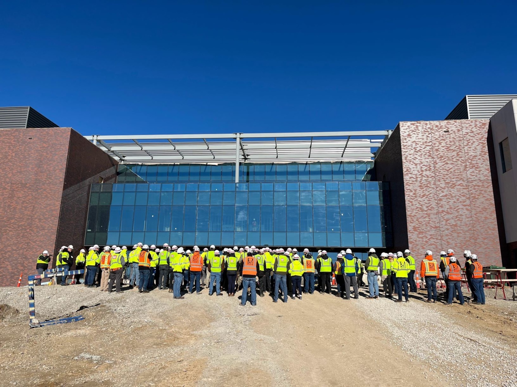 Construction workers listen to ceremony from the front side of the National Geospatial-Intelligence Agency new west headquarters in St. Louis, Mo. Nov. 30, 2022.