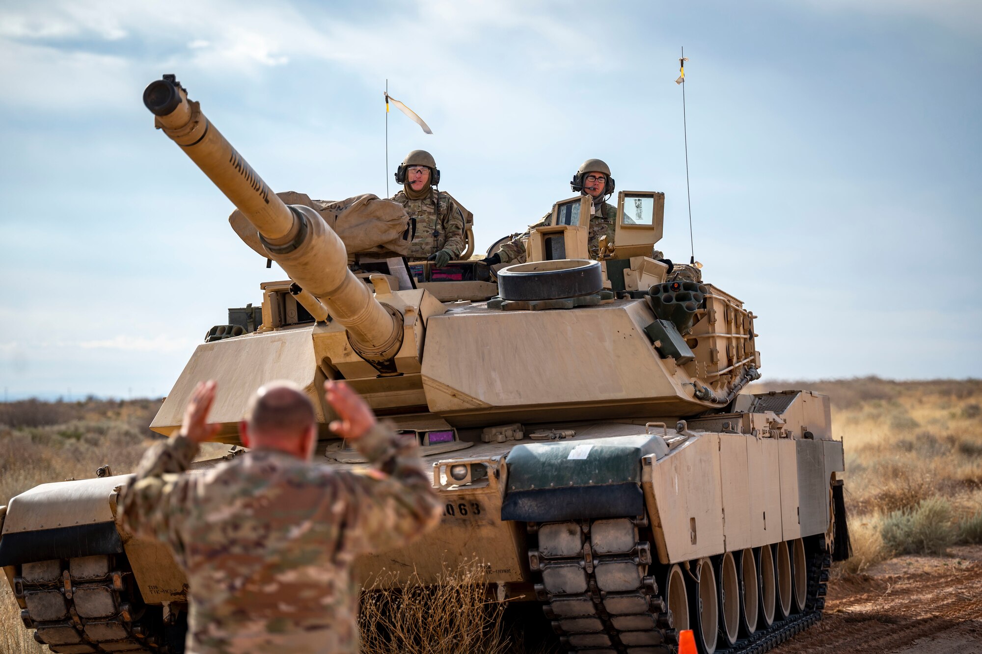 U.S. Army members assigned to the 1st Armored Division move an M1A2 Abrams tank into position to simulate receiving fuel from a C-130J Super Hercules at Fort Bliss, Texas, Dec. 9, 2022. This exercise allowed U.S. forces to practice and showcase their interoperability and joint effectiveness for future contingency operations. (U.S. Air Force photo by Senior Airman Leon Redfern)