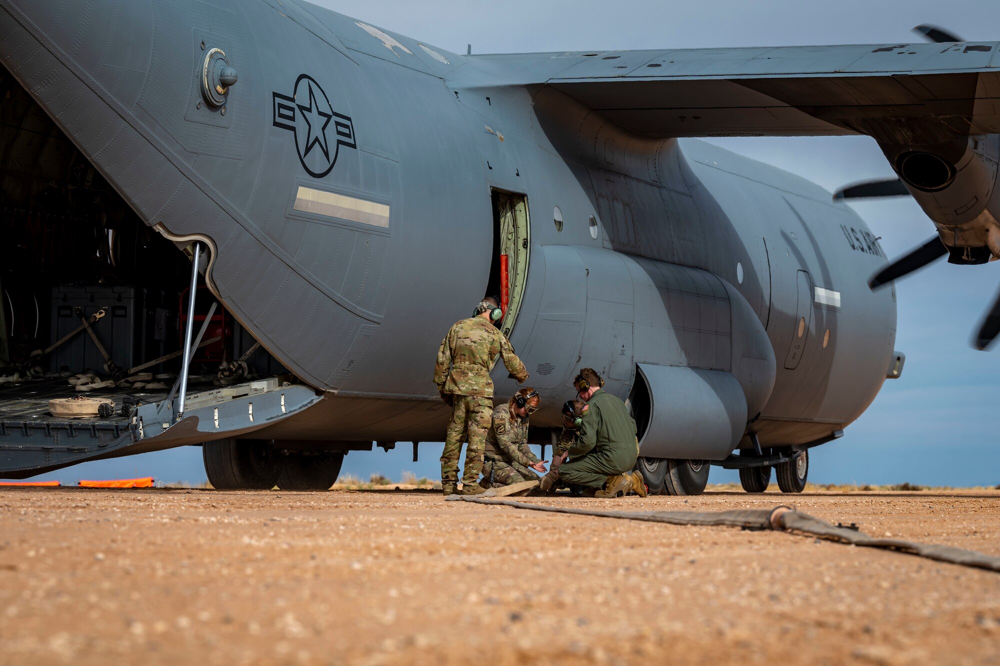 U.S. Airmen from the 40th Airlift Squadron pack up the Emergency Response Refueling Equipment Kit after simulating refueling a M1A2 Abrams tank from a C-130J Super Hercules at Fort Bliss, Texas, Dec. 9, 2022. The ERREK is a specialized fueling equipment used during hot refueling and allows for interoperable and mobile fuel support. (U.S. Air Force photo by Senior Airman Leon Redfern)