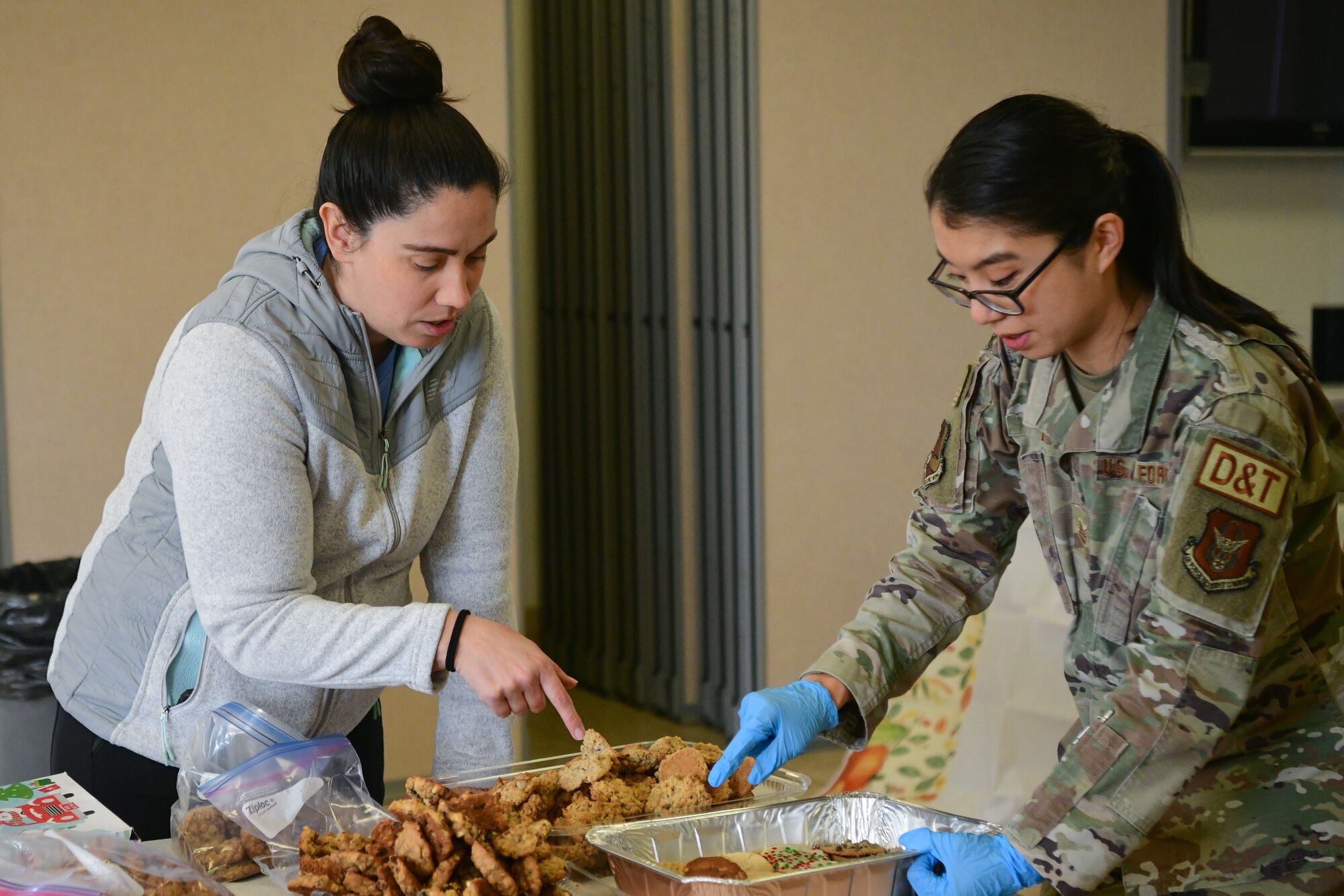 Jennifer Borrego (left) and Tech. Sgt. Michelle Lee package cookies for the Cookie Crunch in the Foothills Chapel on Beale Air Force Base, Calif. on Dec. 16, 2022.