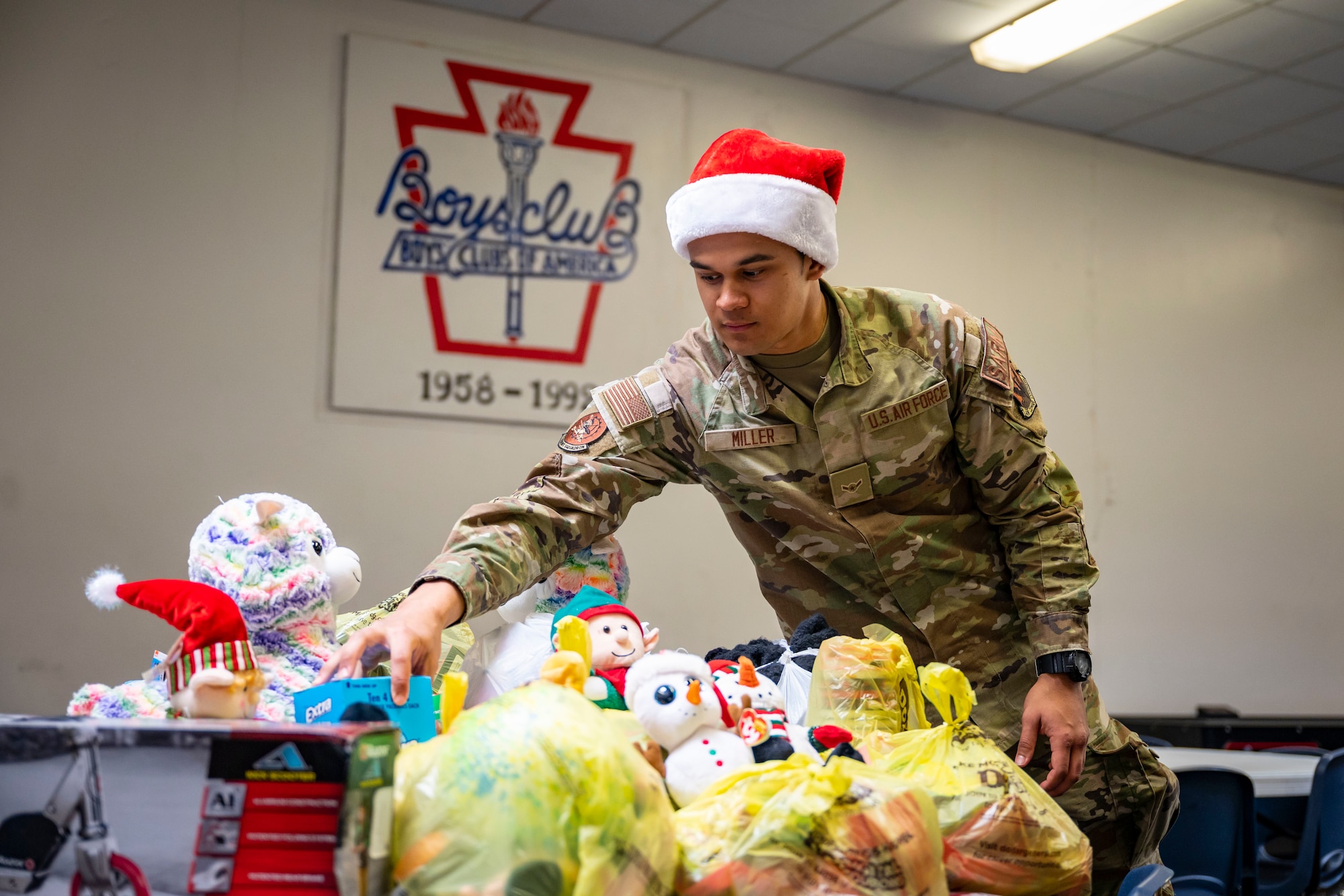 U.S. Air Force Airman Joshua Miller, 77th Weapons Squadron member, places gifts in a donation pile at the Boys and Girls Club of Abilene in Abilene, Texas, Dec. 14, 2022. The RAD team carried bags of toys during the six-mile ruck march to the Boys and Girls Club of Abilene to donate them to those in need. (U.S. Air Force photo by Senior Airman Leon Redfern)