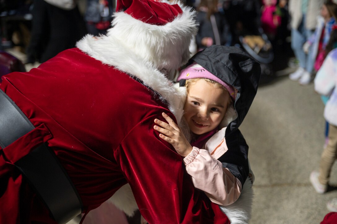 A little girl hugs Santa Claus at WinterFest 2022
