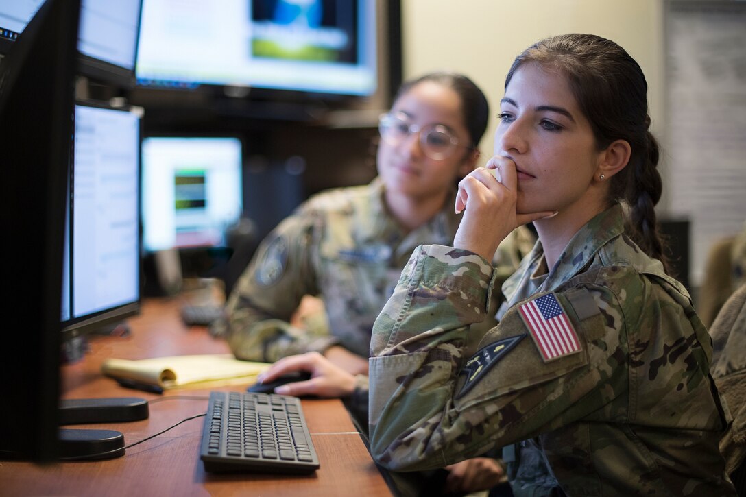 U.S. Space Force 1st Lt. Laura Drapinski, 2d Space Warning Squadron, front, and Spc. 4 Ariana Gonzalez, 11th Space Warning Squadron, back, use a Space-Based Infrared System Simulator to monitor missile indications during simulated combat operations in United States European Command
