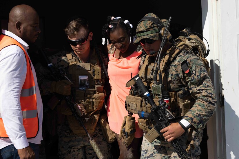 U.S. Marines from 1st Battalion, 8th Marine Regiment, help a local civilian to a treatment site while supporting Continuing Promise 2022 in Jeremie, Haiti, Dec. 12, 2022. The Continuing Promise mission includes providing direct medical care and expeditionary veterinary care, conducting training and subject matter expert exchanges on various medical and humanitarian assistance/disaster relief topics, and leading seminars on Women, Peace, and Security.