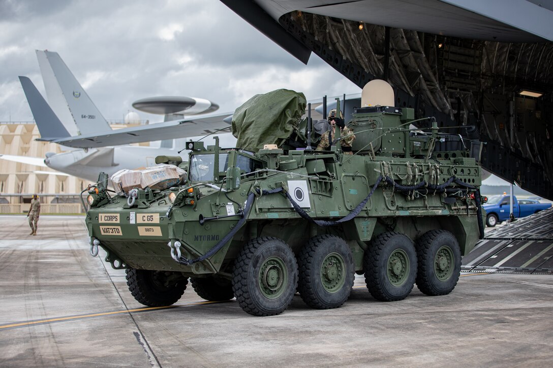 U.S. Army Spc. Jordan Oosting and Maj. Michael Anderson off-load a Stryker combat vehicle from a 62nd Airlift Wing C-17 Globemaster III at Andersen Air Force Base, Guam, Feb. 6, 2022. Members of America’s First Corps deployed from Joint Base Lewis-McChord to Guam to conduct a training exercise that enhances readiness, showcases joint interoperability and exercises distributed mission command in the Pacific. (U.S. Army photo by Spc. Jailene Bautista, 5th Mobile Public Affairs Detachment)