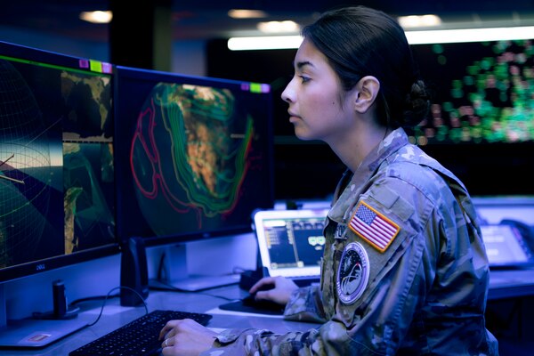 Woman in military uniform looking at computer screen