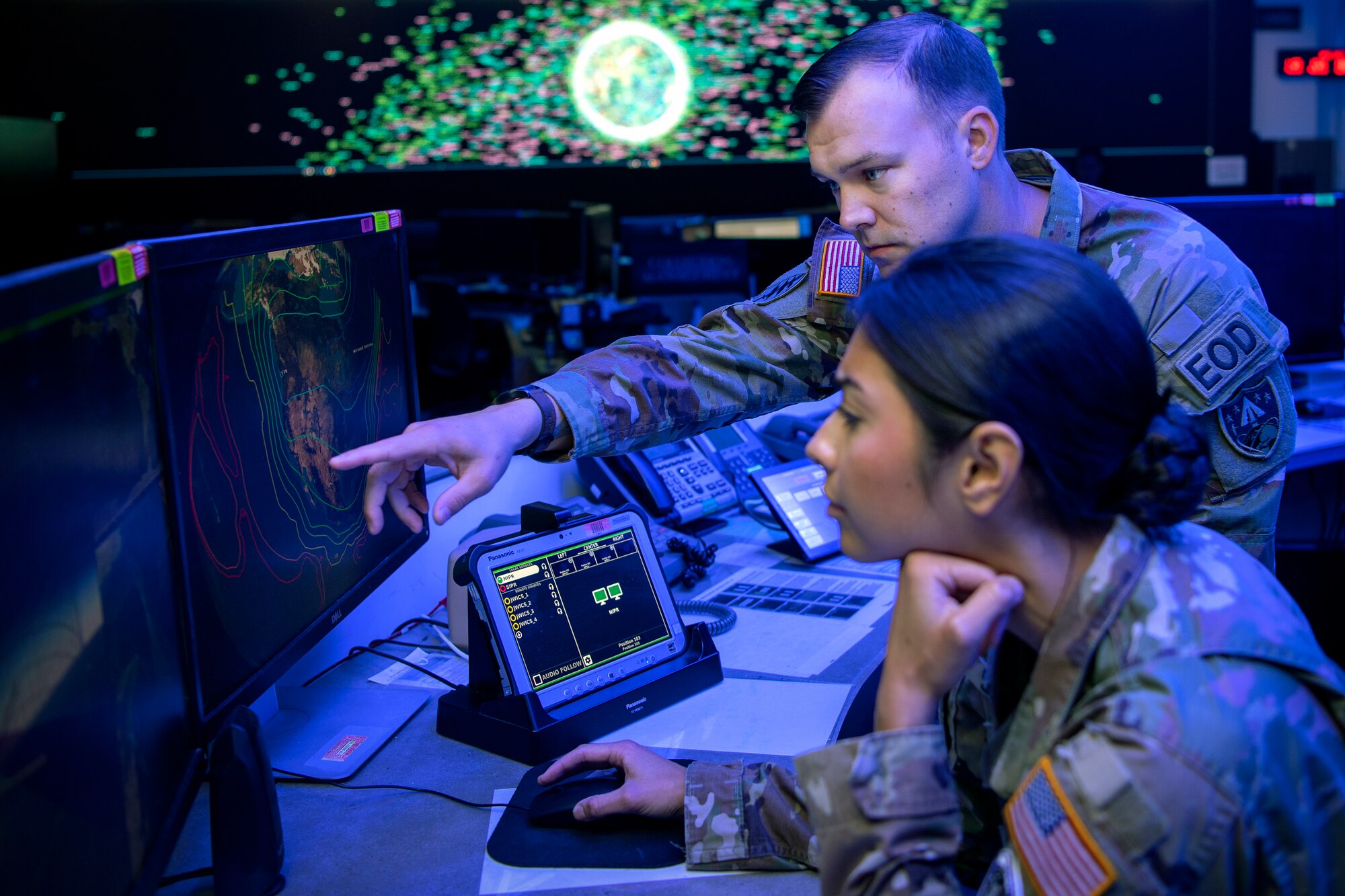 Man and woman in uniform looking at computer screen
