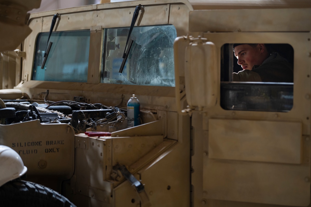 U.S. Air Force Senior Airman Cutlas Greeley, 443rd Air Expeditionary Squadron Air Mobility Flight general purpose mechanic, works on a Humvee electrical system at Al Asad Air Base, Iraq, Dec. 14, 2022. During a recent mission, vehicle maintenance were able to quickly respond and fix a vehicle that had stalled inside an aircraft, enabling the mission to continue. (U.S. Air Force photo by Staff Sgt. Dalton Williams)