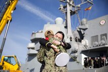 Ens. Madison Sundling assigned to the Arleigh Burke-class guided-missile destroyer USS Paul Ignatius (DDG 117), greets her family on the pier onboard Naval Station Rota, Spain, as Paul Ignatius returns home from its first Forward Deployed Naval Forces-Europe (FDNF-E) patrol, Dec. 20, 2022.