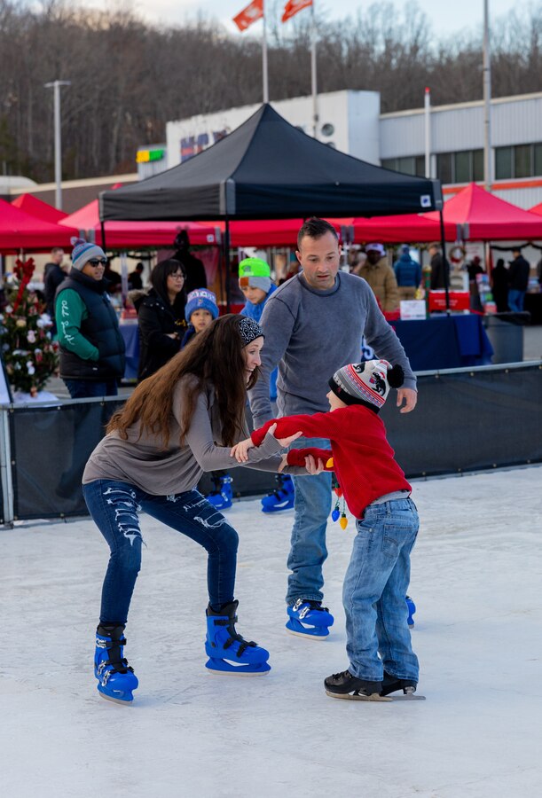 U.S. Marines and their families ice skate during the annual holiday tree lighting at the Marine Corps Exchange parking lot on Marine Corps Base Quantico, Virginia, Dec. 1, 2022. The festivities included an ice-skating rink, snowball fighting, games for children, music performances, and vendor booths all to celebrate the holiday season. (U.S. Marine Corps Photo by Lance Cpl. Kayla LeClaire)