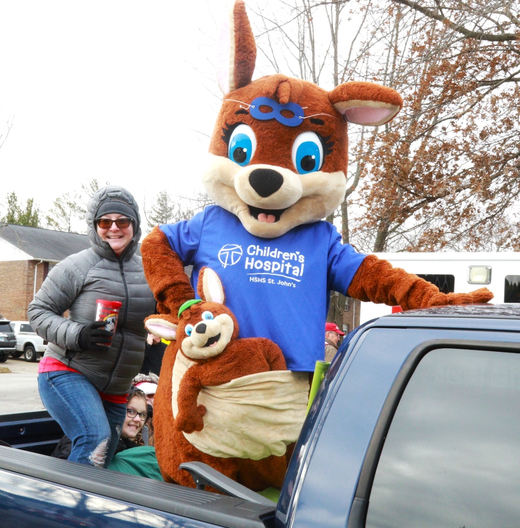 CJ and Joey, the mascots for Hospital Sisters Health System Children's Hospital, pose with Brandy Grove, the HSHS Manager of Philanthropy, as 10-year-old Zoey Beyers peeks out from behind prior to June's parade. The temperature was 23-degrees Fahrenheit, but it was a warm June Day in Auburn, Illinois, Dec. 17 as the Illinois National Guard joined hundreds of first responders and community groups from across the region to give 3-year-old June Peden-Stade a parade.  The Make A Wish Foundation reached out to the City of Auburn with June's wish this week and supporters flocked in from all over Central Illinois to make the parade a reality, including 10 trucks and about 20 Soldiers from the Illinois Army National Guard's 232nd Combat Sustainment Support Battalion; Charlie Company of the 634th Brigade Support Battalion; Battery B of the 2nd Battalion, 123rd Field Artillery; and the 3637th Maintenance Company - all based in Springfield.