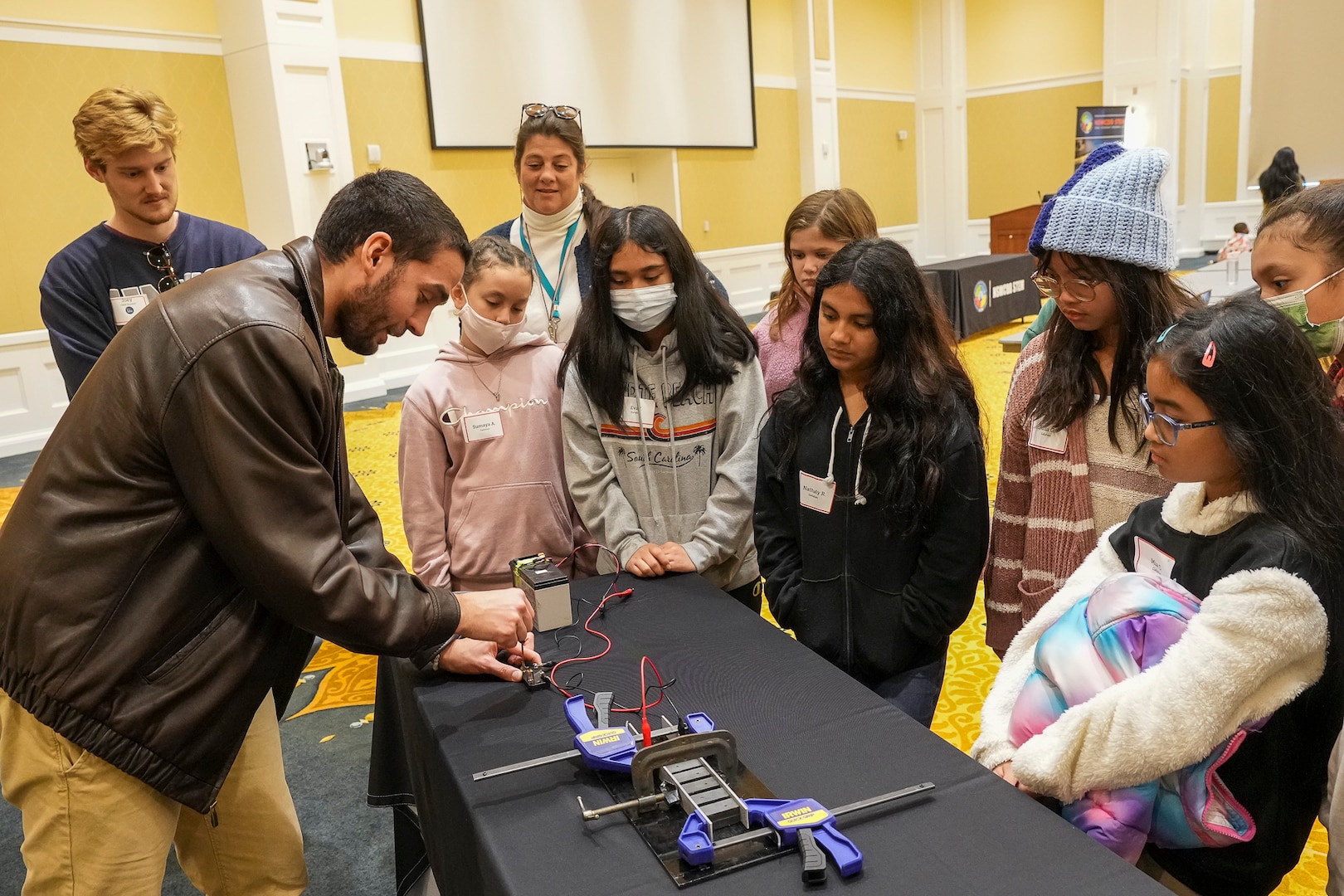 IMAGE: Naval Surface Warfare Center Dahlgren Division (NSWCDD) engineer Elliott Armstrong demonstrates how a railgun uses electricity and magnetism to launch a projectile for a group of Harrison Road Elementary School fifth graders. This was one of several STEM-related demonstrations that NSWCDD personnel put on for students during their field trip to the University of Mary Washington.