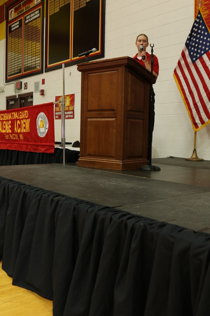 Cadet Ellie McDonald, distinguished honor graduate, addresses her graduating class and emphasizes that every graduate should be beyond proud of themselves during the Wisconsin National Guard Challenge Academy Graduation 17 at Sparta High School, Sparta, Wis. After graduating from the 22-week residential phase of academy training, cadets work with hometown mentors who offer guidance and encouragement in pursuing their new direction in life. The National Guard Youth Challenge Program currently operates 40 programs in 29 states, Puerto Rico and the District of Columbia. Nationwide, more than 190,000 teens have graduated from this free program since its inception in 1993. (Wisconsin National Guard Photo)