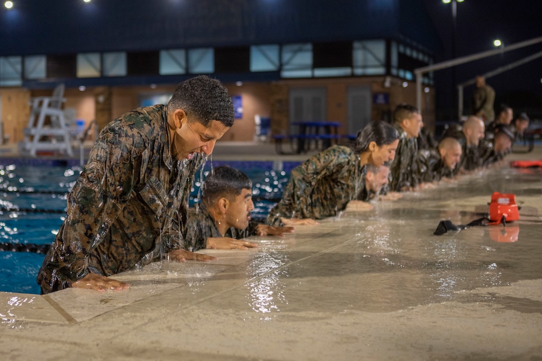 Marines with Marine Forces Reserve conduct physical training in the pool during a Marine Corps Martial Arts Program (MCMAP) Instructor Course on Naval Air Station Joint Reserve Base New Orleans, Dec. 13, 2022. The course is intended to prepare Marines to become Marine Corps martial arts instructors for their units. The physical training session is part of strengthening the Marine Corps future MCMAP instructors. (U.S. Marine Corps Photo by Lance Cpl. Mitchell Collyer)