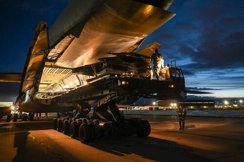 The wings of an F-22 Raptor emerge from inside a C-5M Galaxy