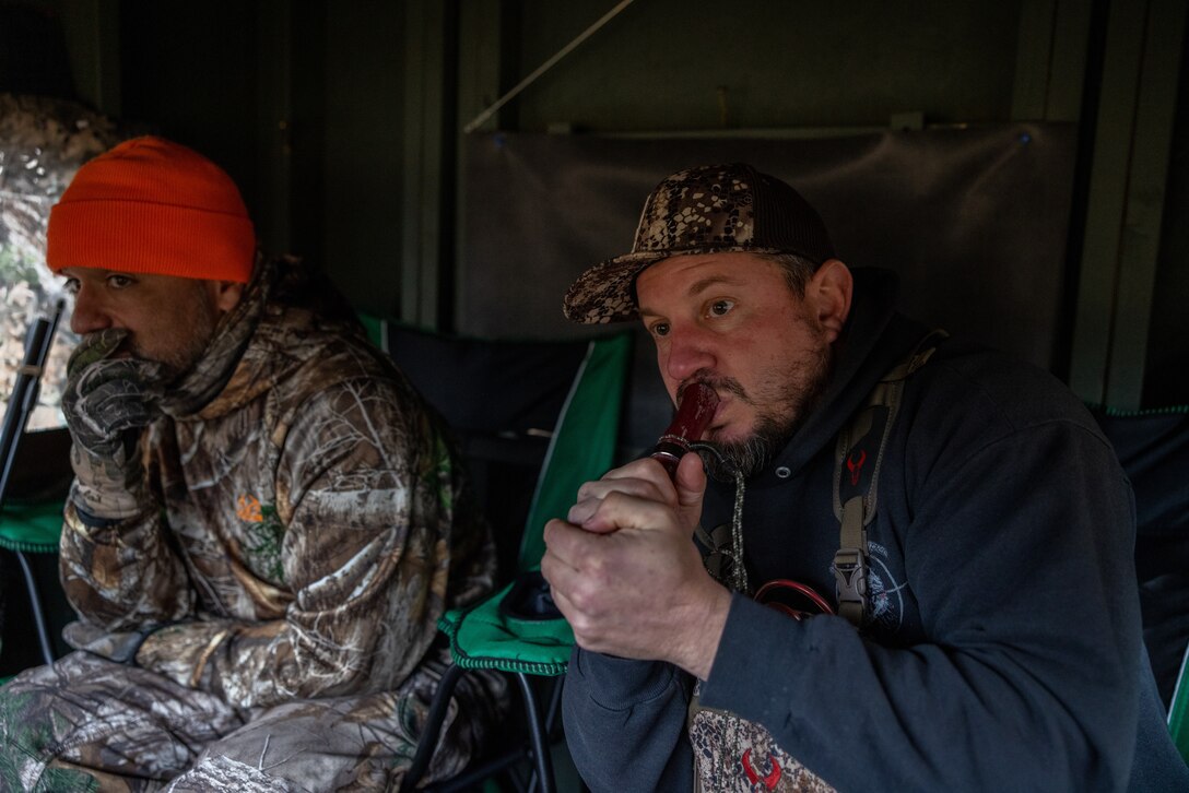 U.S. Marine Corps Master Sgt. Paul Starner, right, retired, serving as a volunteer hunting guide for Quantico Injured Military Sportsmen Association, uses a game call to attract deer during a hunting event on Marine Corps Base Quantico, Virginia, Dec. 10, 2022. The QIMSA program provides combat-injured military members undergoing treatment at Walter Reed, Bethesda, or any other hospital in the nation’s capital region the opportunity to realize their hunting and fishing potential, regardless of injury, in the company of fellow veterans and sportsmen. (U.S. Marine Corps photo by Lance Cpl. Jeffery Stevens)