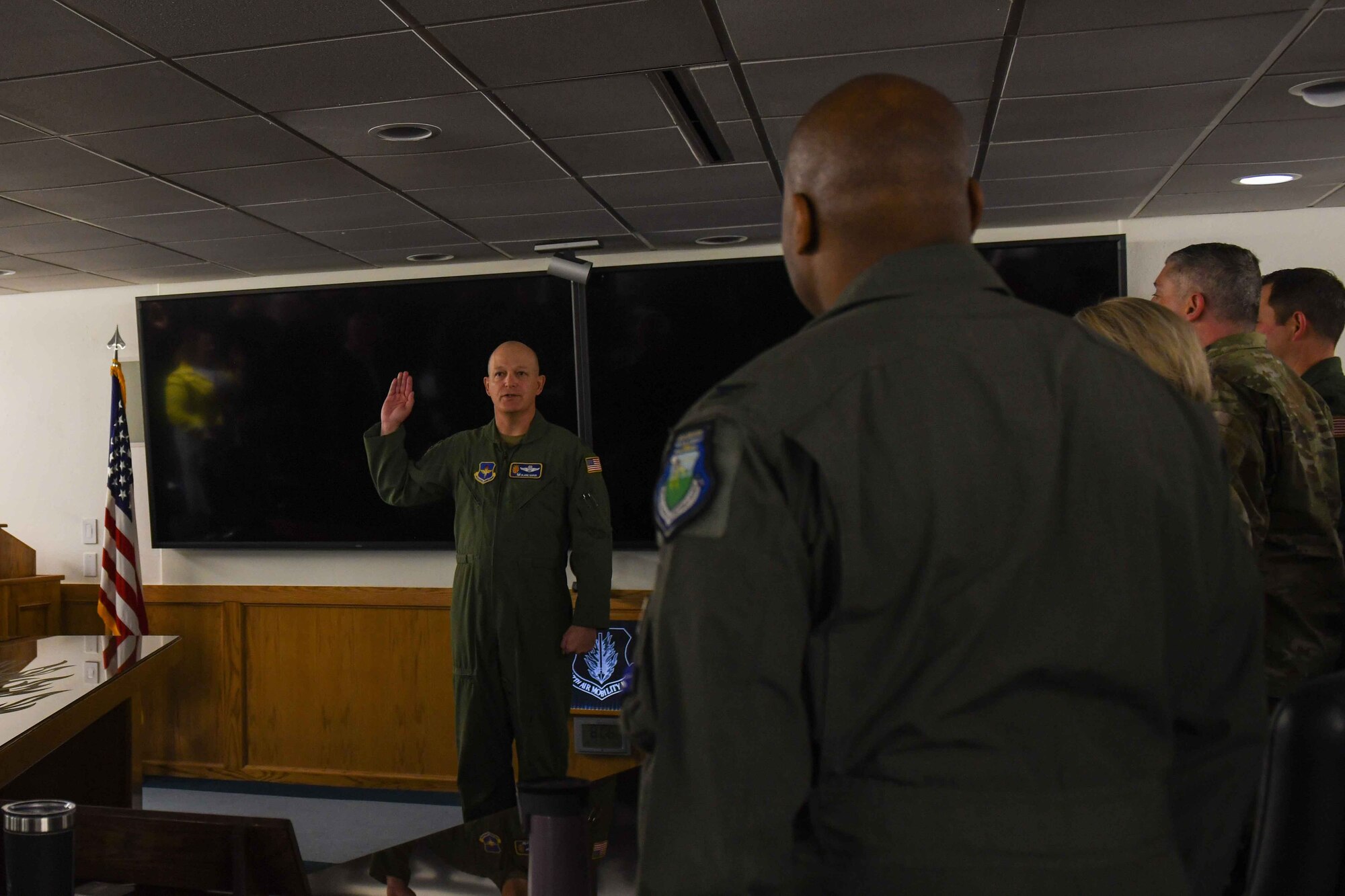 U.S. Air Force Col. Blaine Baker, 97th Air Mobility Wing commander, administers a service oath to civilian employees at Altus Air Force Base, Oklahoma, on Dec. 19, 2022. The oath, which is recited by the civilians to form a bond to their military counterparts, is very similar to the one service members take on the day of their enlistment. (U.S. Air Force photo by Airman 1st Class Kari Degraffenreed)