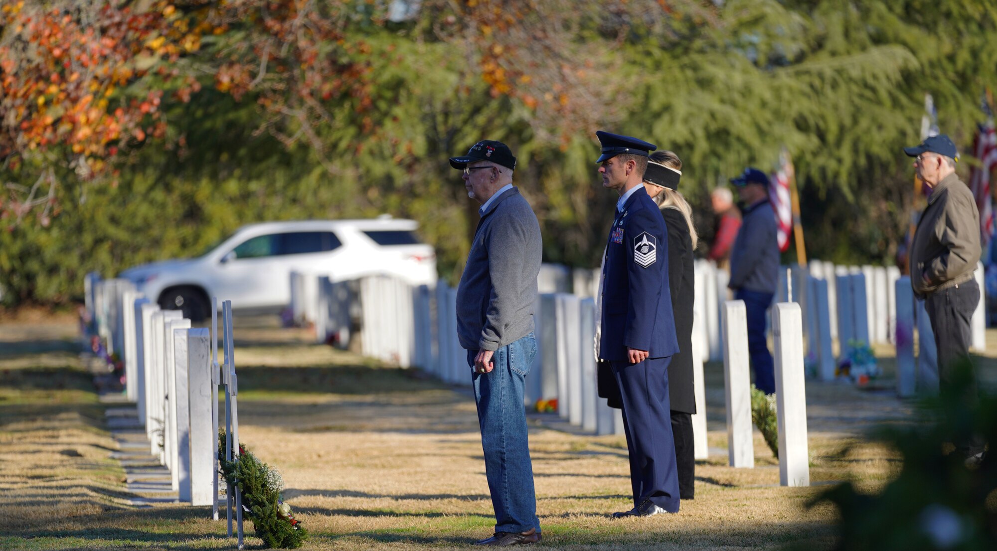 Former and current members of all military branches of service stand before tombstones at the Sutter Cemetery, Dec. 17, 2022, at Sutter, Calif.