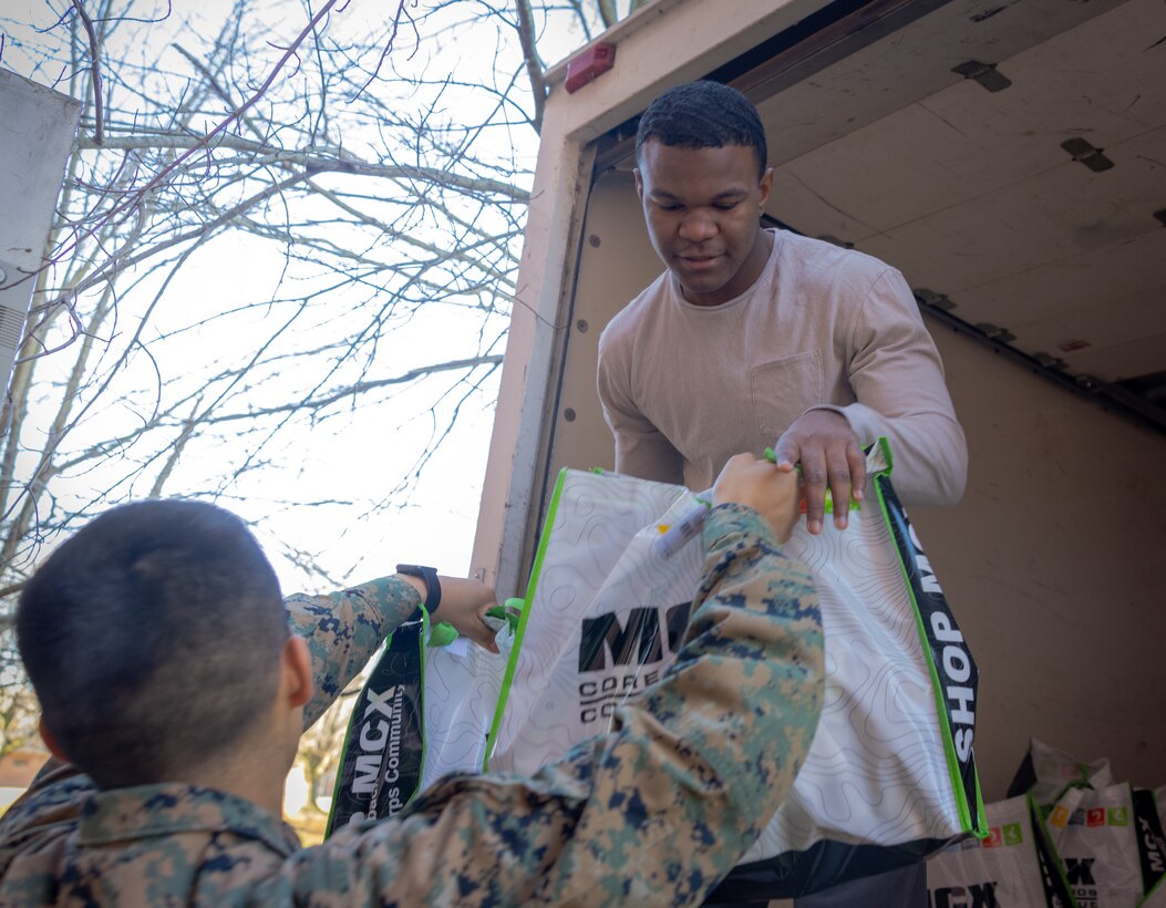 U.S. Marine Corps Lance Cpl. Joshua Cooper, admin clerk with Marine Corps Embassy Security Group, participates in the Holiday in the Barracks bag stuffing event hosted by the Marine Corps Base Quantico Single Marine Program at the Semper Fit Barber Gym on Marine Corps Base Quantico, Virginia, Dec. 16, 2022. During the Holiday in the Barracks bag stuffing, Quantico's Single Marine Program and additional volunteers, stuffed 300 gift bags for active duty single Marines in preparation for the Holiday in the Barracks event.  (U.S. Marine Corps photo by Lance Cpl. Jeffery Stevens)