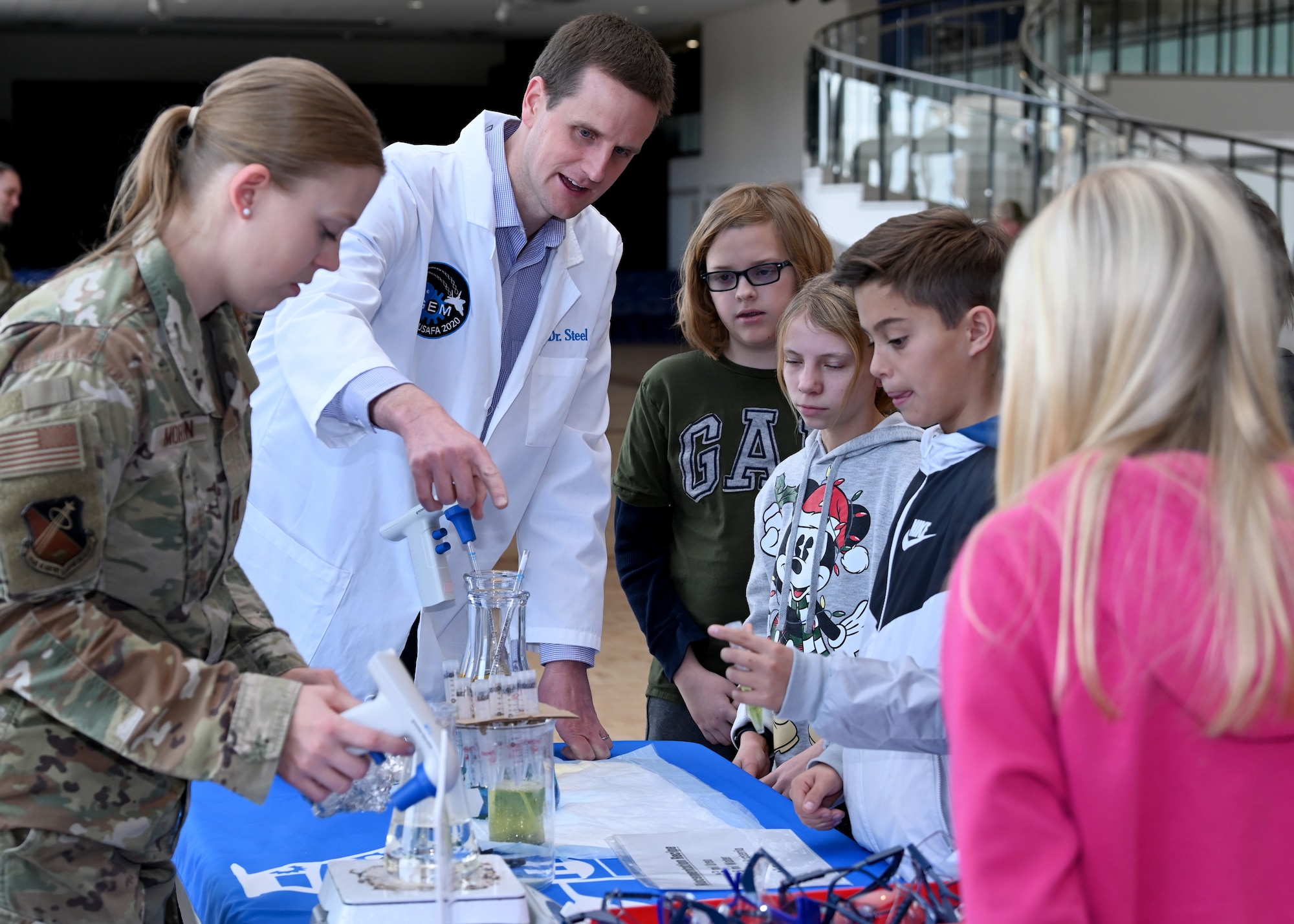 Air Force Academy Biology professors show a small group of elementary school students an example of biocementation during a STEM-to-Space event at the Academy, December 15, 2022.