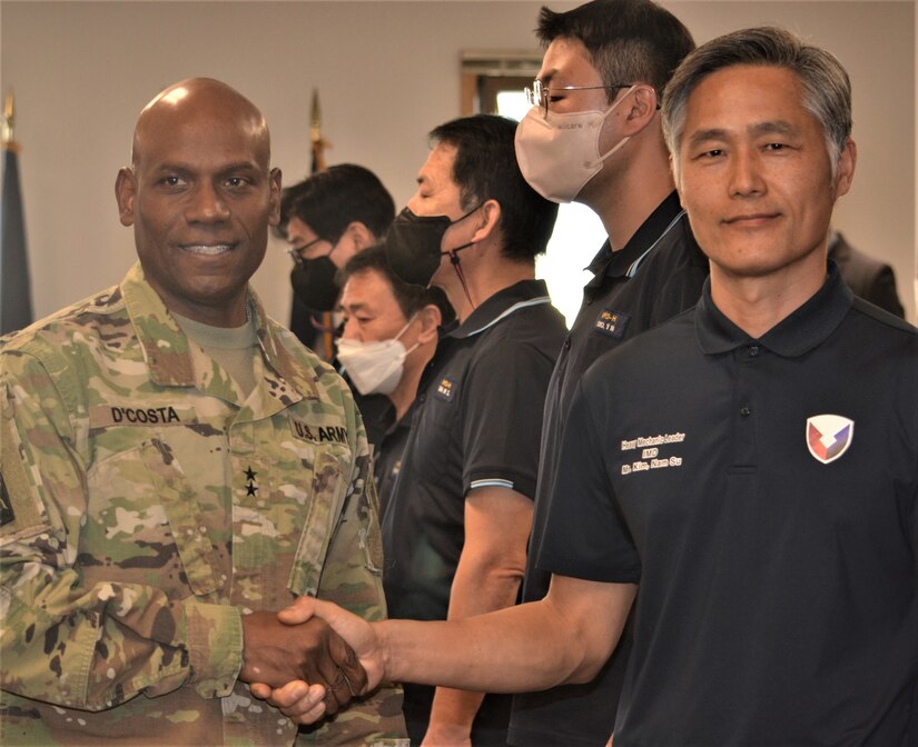 Maj. Gen. Joseph D’costa, deputy commanding general – sustainment, Eighth Army, congratulates Kim, Nam Su, heavy shop leader, Maintenance Division, Army Field Support Battalion–Korea, during the Fiscal Year 2022 Army Award for Maintenance Excellence Presentation Ceremony at Camp Humphreys, South Korea, Dec. 8, 2022.